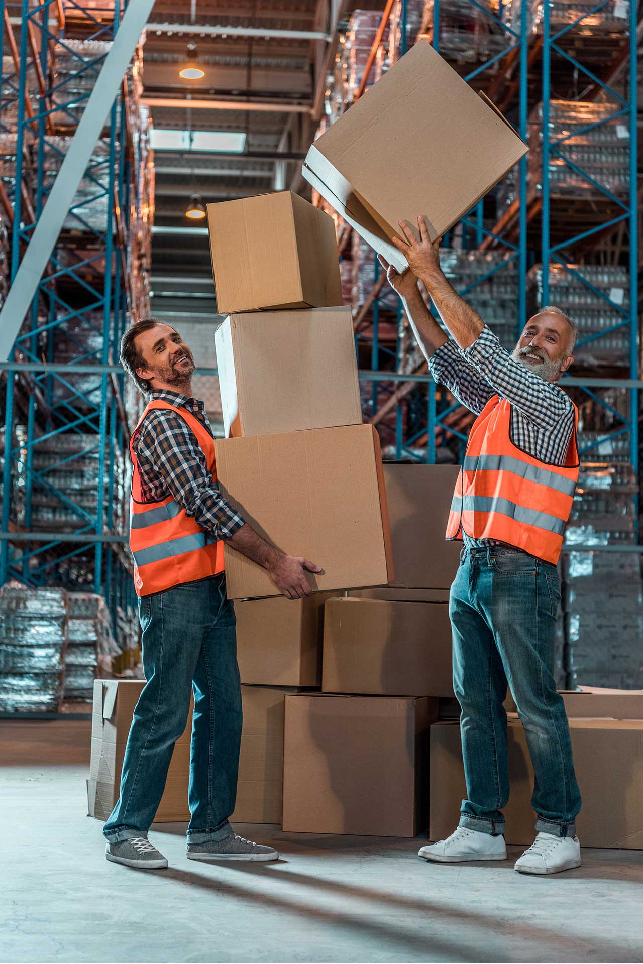 smiling warehouse workers holding stacked boxes an 2023 11 27 05 18 45 utc